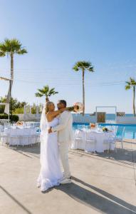 a bride and groom dancing at their wedding on the beach at Thalasses in Adelianos Kampos +76 photos