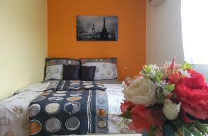 オロモウツにあるApartmán 4U Olomoucのベッドルーム1室(花の飾られたベッド1台付)