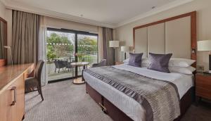 a hotel room with a large bed and a balcony at St. Pierre Park Hotel & Golf in St. Peter Port +72 photos