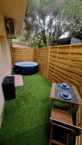 a backyard with a wooden fence and a trampoline at Studio cosy avec jacuzzi , sauna et salle de sport in Vallauris