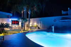 a swimming pool in a backyard at night at HOLIDAYS ALBA in Catania +31 photos