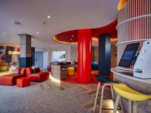 a living room with red furniture and a tv at Sholeo Lodges Los Gigantes in Puerto de Santiago