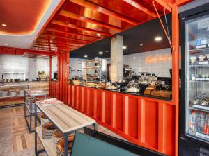 a restaurant with red walls and a counter with a table at Sholeo Lodges Los Gigantes in Puerto de Santiago