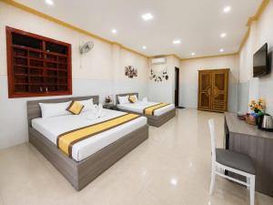 a hotel room with two beds and a television at Viora Hotel in Ấp Phước Thiện