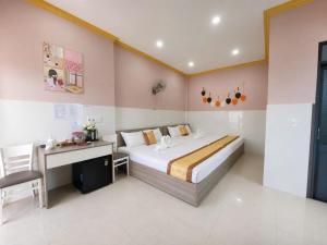 a bedroom with a large bed and a desk in it at Viora Hotel in Ấp Phước Thiện