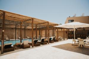 a resort with a pool and chairs and an umbrella at DUNIA Desert Suites in Mitzpe Ramon