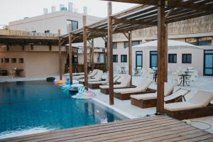 a swimming pool with lounge chairs and a hotel at DUNIA Desert Suites in Mitzpe Ramon