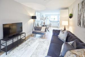 a living room with a couch and a flat screen tv at The Madison Garden in Whitby