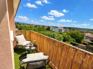 a balcony with two chairs and a table and a fence at Le Panorama Chic 4prs-Parking in Bourg-en-Bresse