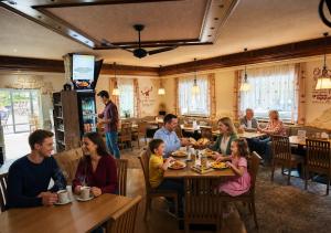 a group of people sitting at a table in a restaurant at Garden Depandance Am Bach in Kurort Altenberg