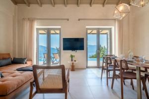 a living room with a table and a dining room at Villa Thalassa by Villa Select in Fiskardo