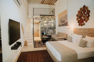 a hotel room with a bed and a television at DUNIA Desert Suites in Mitzpe Ramon +241 photos
