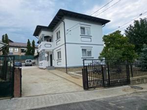a white house with a black roof at Urban Nest in Călimăneşti