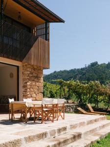 a patio with a table and chairs in front of a house at Casa do Lagar by Quinta de Recião in Lamego