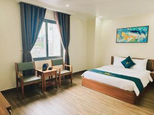 a hotel room with a bed and a table and chairs at White Crown Hotel Ha Long in Ha Long +24 photos