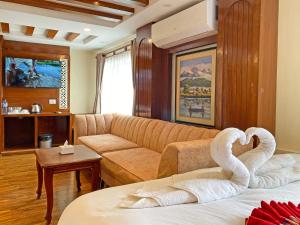 ein Wohnzimmer mit einer Couch und Schwänen auf einem Bett in der Unterkunft Hotel Malati in Kathmandu