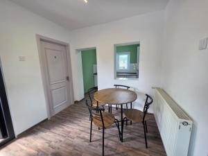 a dining room with a table and chairs in a room at Urban Nest in Călimăneşti