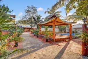 a gazebo in a courtyard with a pool at Falcon's Retreat in Pune