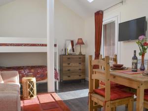 a living room with a desk and a bunk bed at Mango Pony's Bothy - Uk31959 in Dibaig