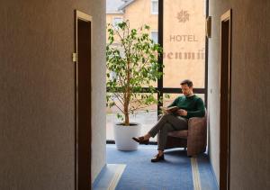 a man sitting in a chair reading a book at Garden Depandance Am Bach in Kurort Altenberg