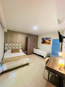 a large bedroom with two beds and a table at HOTEL ROMA VIp in Pereira