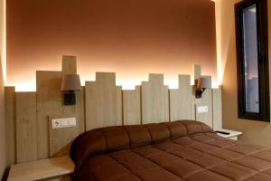 a bedroom with a bed with a wall made out of wood at Cal Miqueló 1778 in Puig-Gros