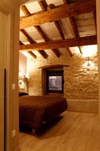 a bedroom with a bed in a stone wall at Cal Miqueló 1778 in Puig-Gros