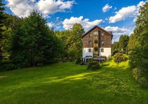 an old barn on a green field with trees at Garden Depandance Am Bach in Kurort Altenberg