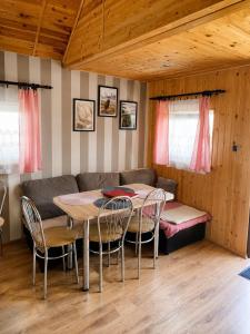 a room with a table and chairs and a couch at Domki POD ŚNIEŻNĄ in Marianówka