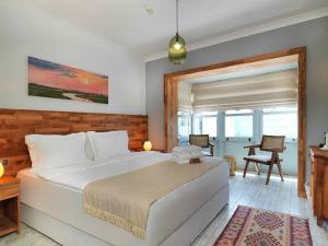 a bedroom with a large white bed and a table at Triangulo Hotel in Alaçatı +38 photos