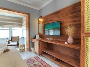 a living room with a television on a wooden wall at Triangulo Hotel in Alaçatı