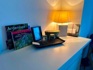 a table with a lamp and books and glasses on it at La Pacha, chambre d'hôtes in Spa