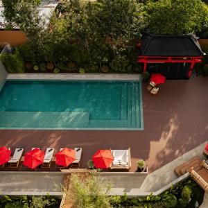 an overhead view of a swimming pool with chairs and umbrellas at Zen Essence Khao Yai in Khao Yai