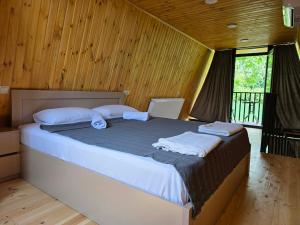 a bedroom with a large bed with white pillows at Diamond Cottages in Lagodekhi