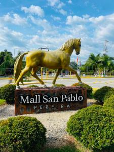 a statue of a horse in front of a sign at HOTEL ROMA VIp in Pereira