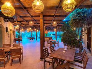 a restaurant with wooden tables and chairs and lights at Triangulo Hotel in Alaçatı