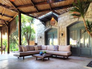 a living room with a couch on a patio at Triangulo Hotel in Alaçatı