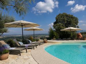 a swimming pool with umbrellas and lounge chairs at Delser Verona Manor House in Verona