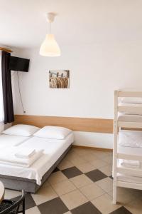 a room with two beds and a book shelf at Obłoczek in Łeba
