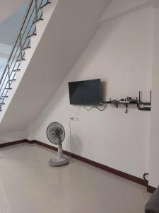 a white room with a fan and a tv at Meena Home Hatyai in Ban Khlong Hae