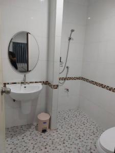 a bathroom with a sink and a mirror and a toilet at Meena Home Hatyai in Ban Khlong Hae