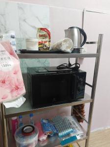 a microwave sitting on a shelf in a kitchen at Meena Home Hatyai in Ban Khlong Hae