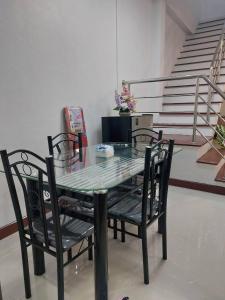 a glass table and chairs in a room with stairs at Meena Home Hatyai in Ban Khlong Hae +16 photos