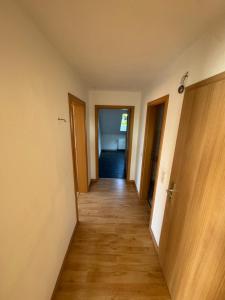 a hallway of an apartment with wooden floors and doors at Unterkunft in Stadtnähe in Gütersloh