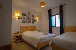 a bedroom with two beds and a window at Palais Taroudant in Taroudant