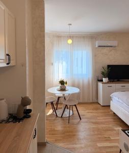 a kitchen and living room with a table and a couch at Tiffany apartment - Podgorica in Podgorica