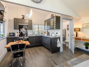 a kitchen with black cabinets and a wooden table at The Pavilion in Swaton