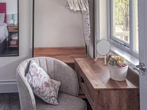 a room with a chair and a table and a mirror at The Pavilion in Swaton