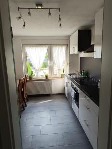 a kitchen with white cabinets and a large window at Haus Berta in Spremberg