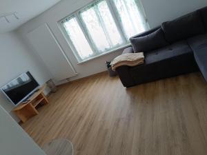 a living room with a black couch and a wooden floor at Haus Berta in Spremberg